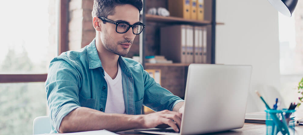 Male medical student working on laptop in study space