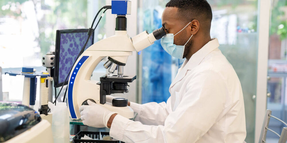 Cytopathologist examining samples under microscope