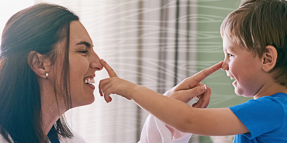 Doctor with a child patient with each touching the other’s nose