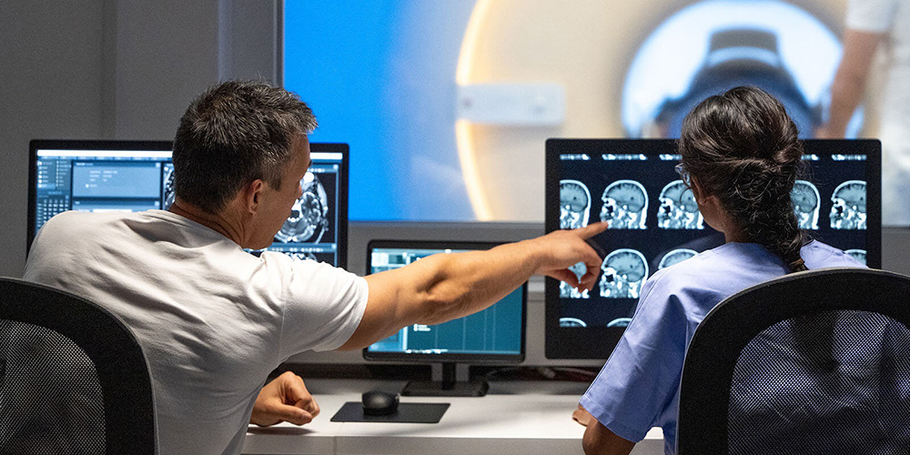 Two medical providers reviewing radiology scans