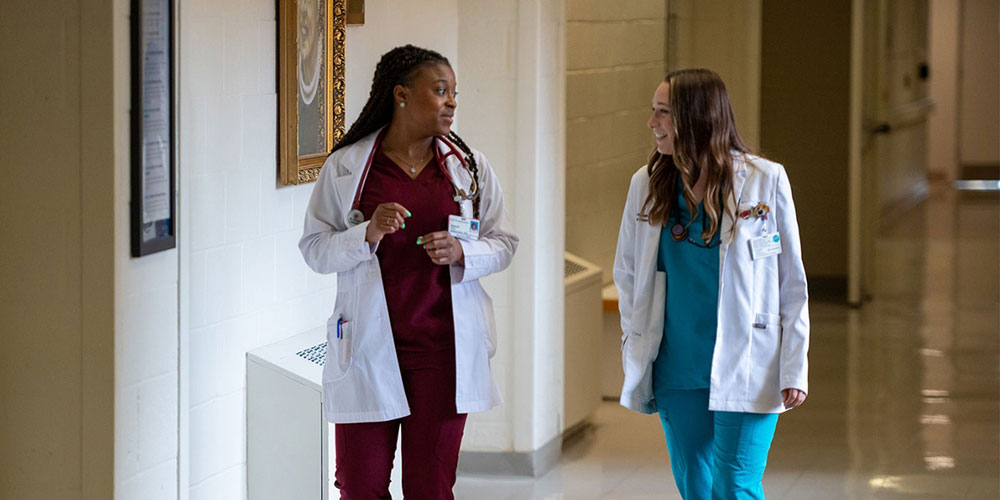 Two SGU residents converse in a hospital setting