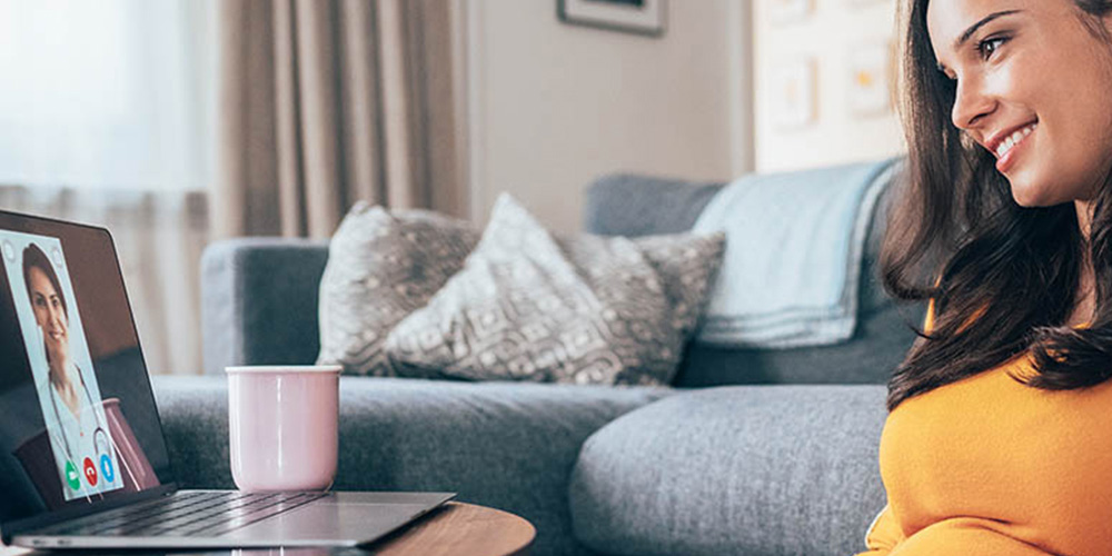 Pregnant woman on a video call with her female physician.