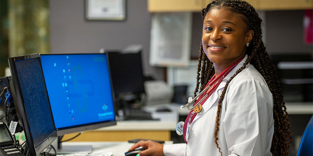 Smiling SGU student at a hospital desk