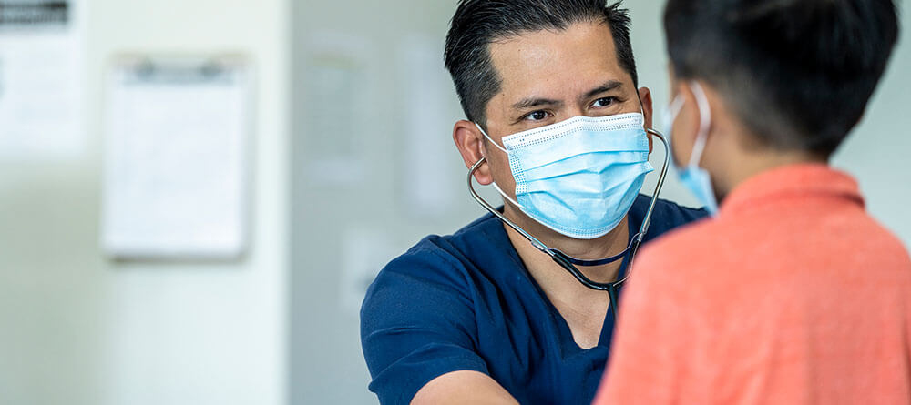 Family medicine physician listening to child's heart