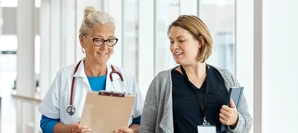 Medical school applicant shadowing older female physician.