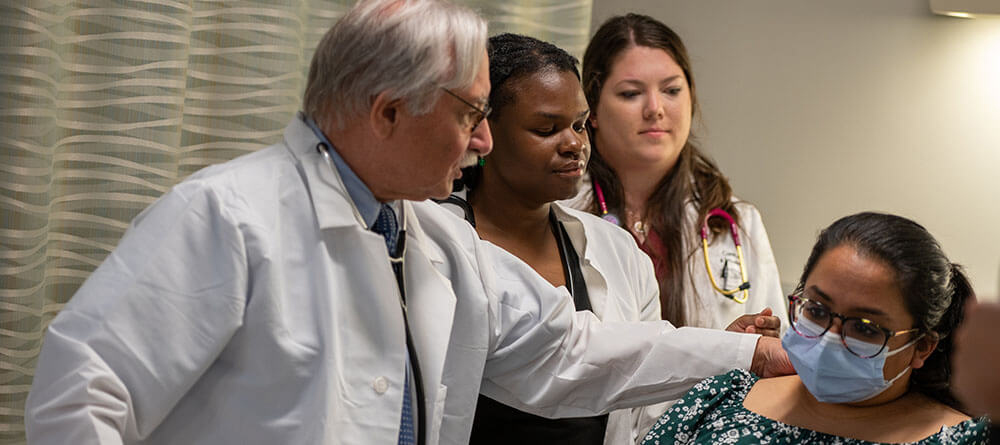 SGU medical students receive hands on learning during a patient exam.