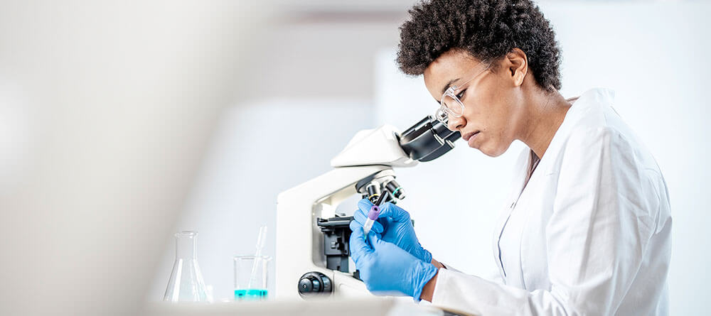 A pathologist marks a test tube in a laboratory setting