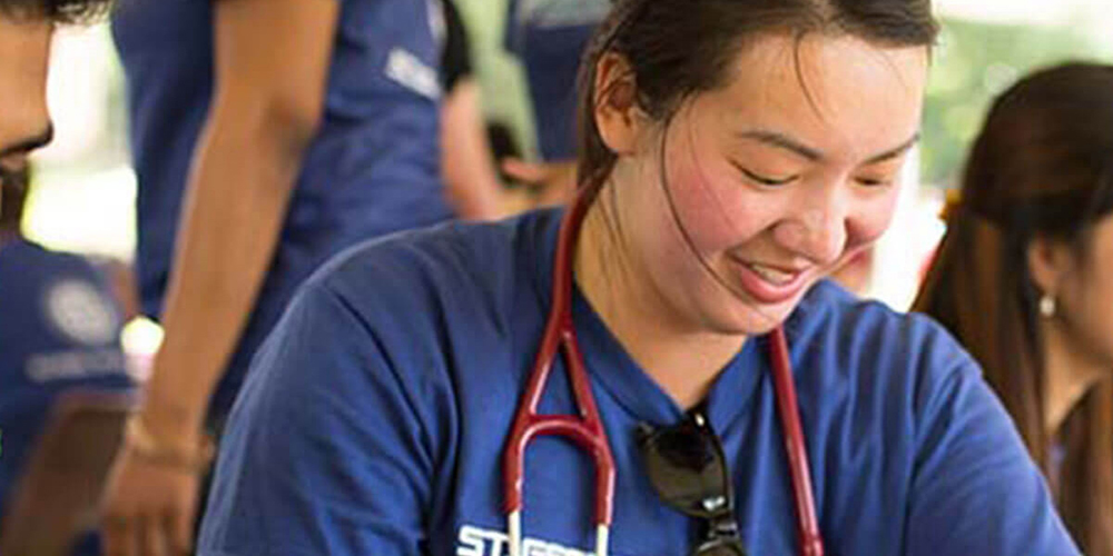 A small group of SGU students volunteer their time conducting physical exams during an outdoor clinic.|Skip the Med School Waitlist. Episode 1: 4 Perks of attending an international medical school.