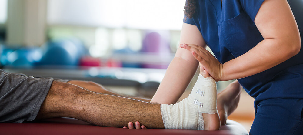 Physical therapist stretching a man's calf muscle