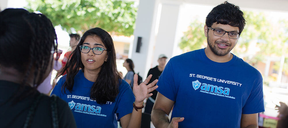 SGU students speaking in a group on campus.