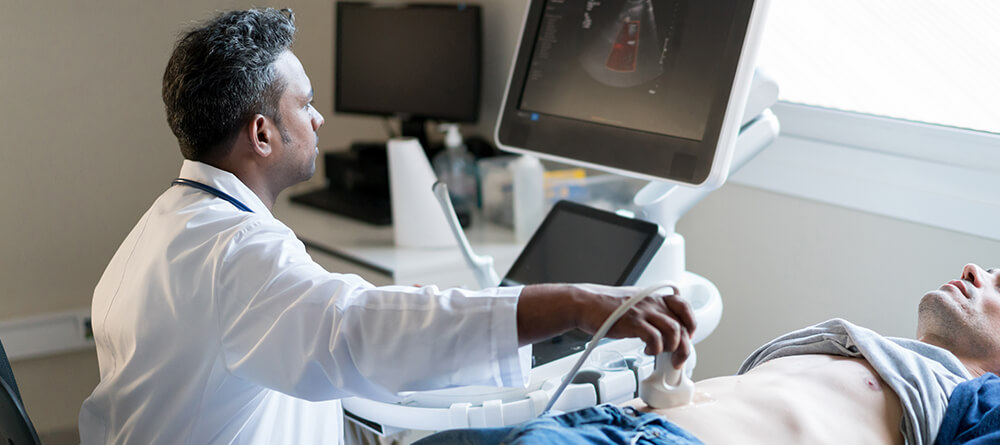 Male physician performing an ultrasound on a patient's abdomen