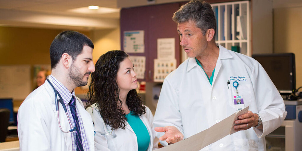 SGU students talking with physician in hospital|Physician speaking with patient in exam room|SGU students smiling after matching for residency|SGU students walking on campus in Grenada
