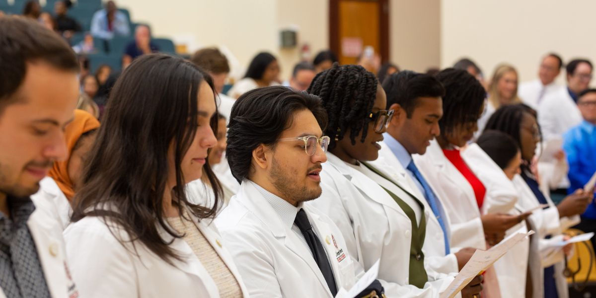 medical students reading oath at white coat ceremony