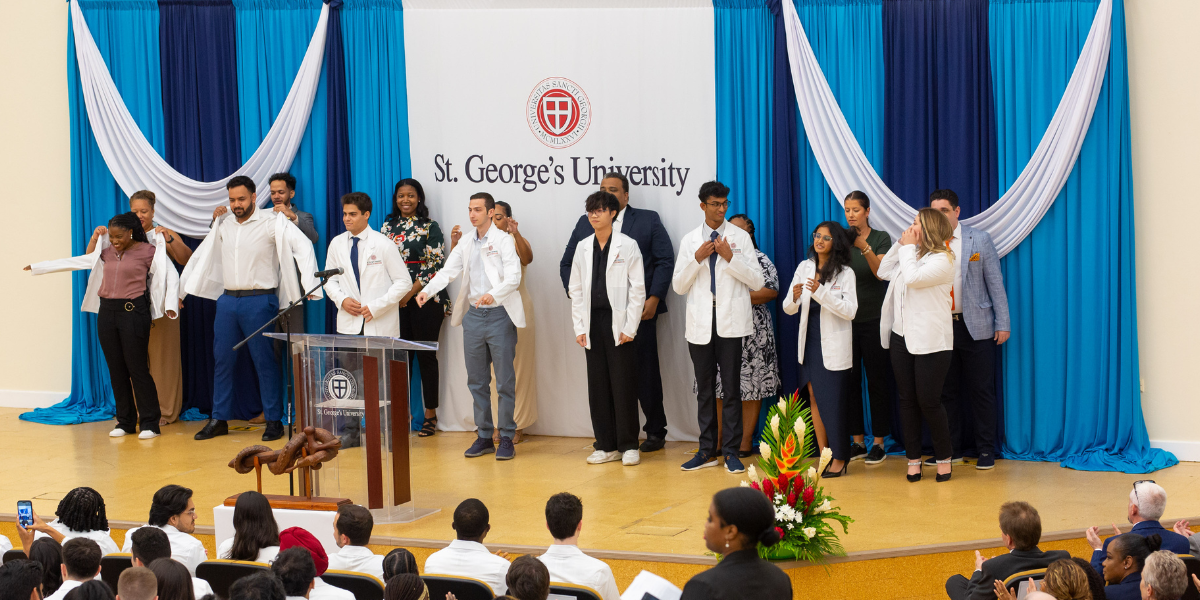 medical students on stage at white coat ceremony