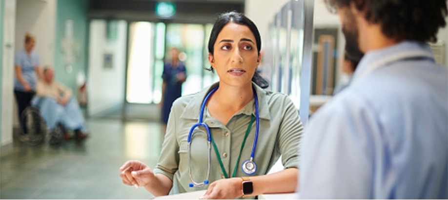 A doctor discusses a patient's chart with a nurse.