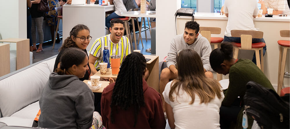 Group of SGU students eating together in a lounge area