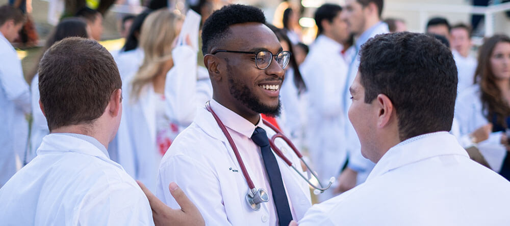 SGU medical students congratulate each other following their white coat ceremony
