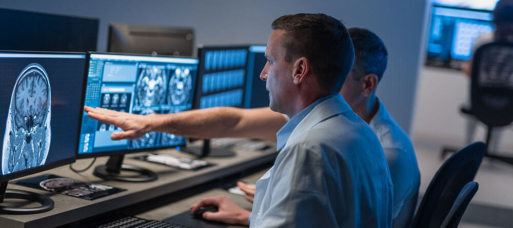 A doctor examines and discusses MRI imaging with a colleague
