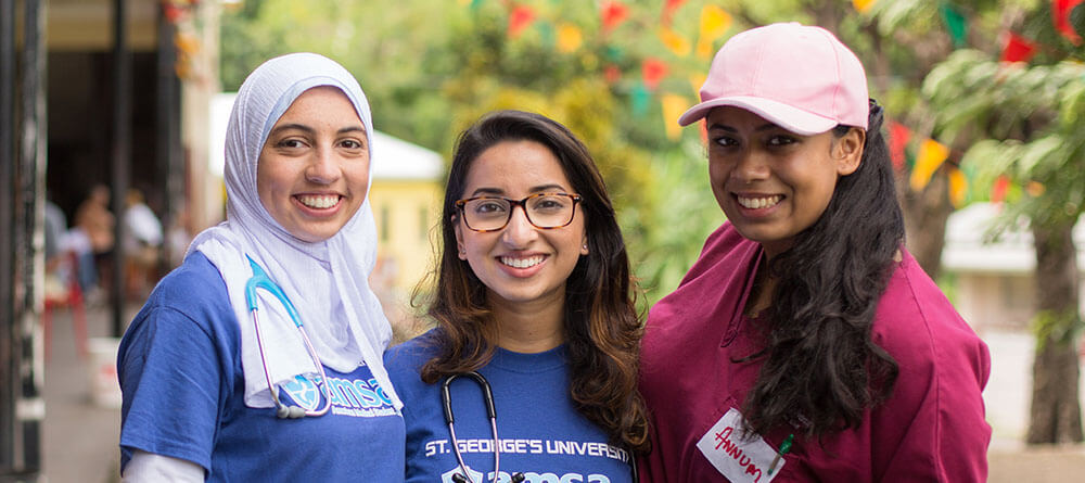A trio of SGU students pose for a picture at a community outreach event