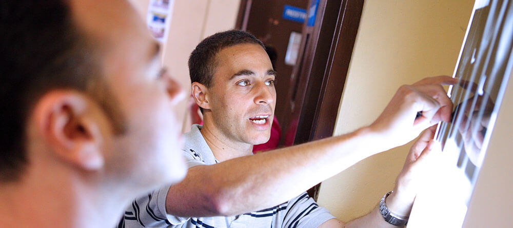 Radiologists point to x-ray on the wall