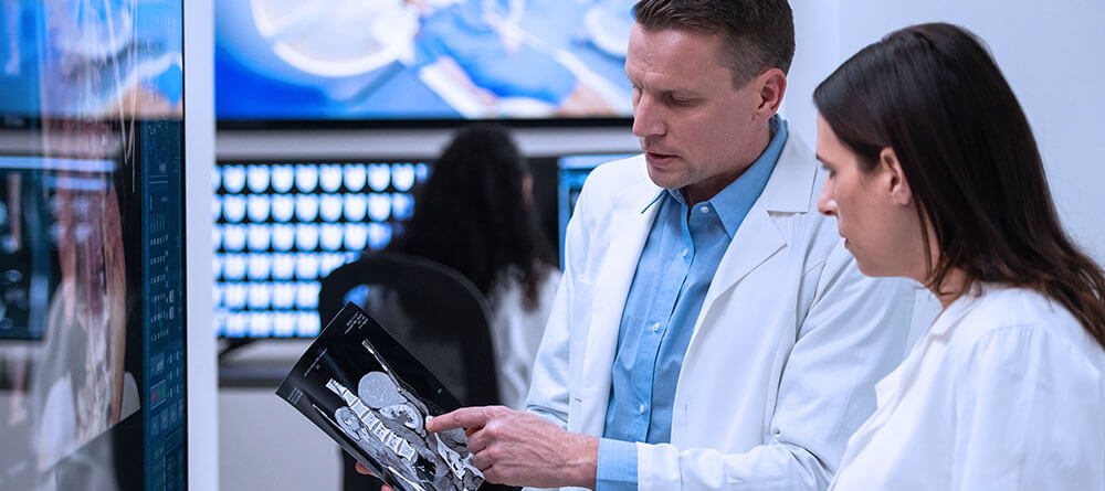 Radiologist examining x-ray with another provider